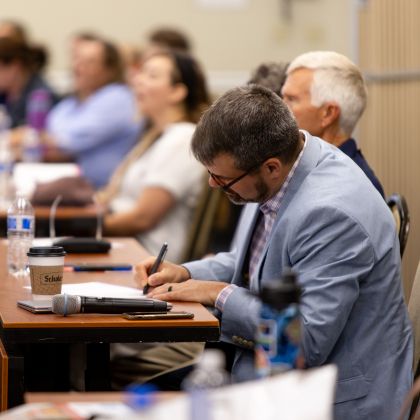 Dr. Gibson taking notes in conference