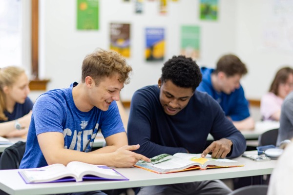 Male teacher teaching another male student