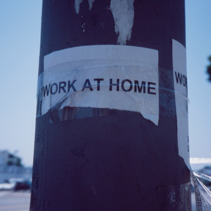 A photo of a paper taped to a pole with the words Work At Home