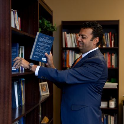 Dr. Ibrahim putting books on a shelf