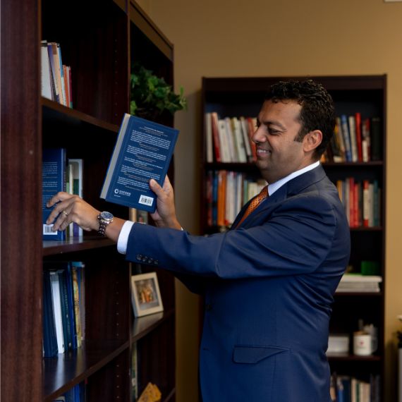 A.S. Ibrahim putting a book on a shelf
