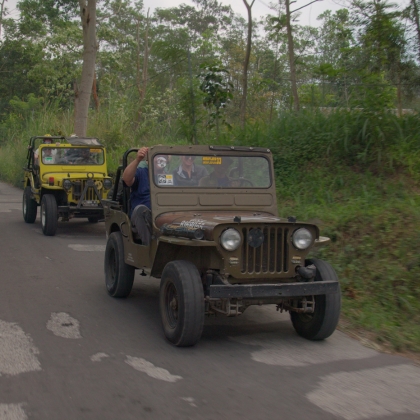 Two jeeps driving down road
