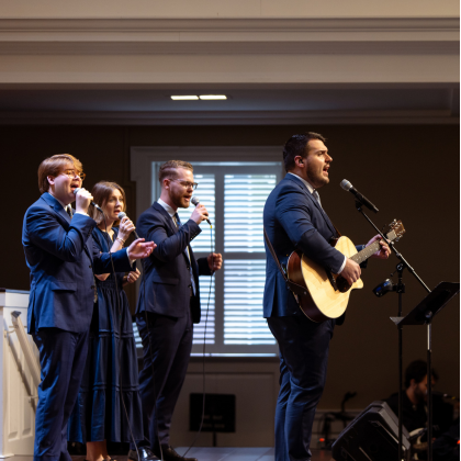 Worship band performing on stage with singer and guitarist